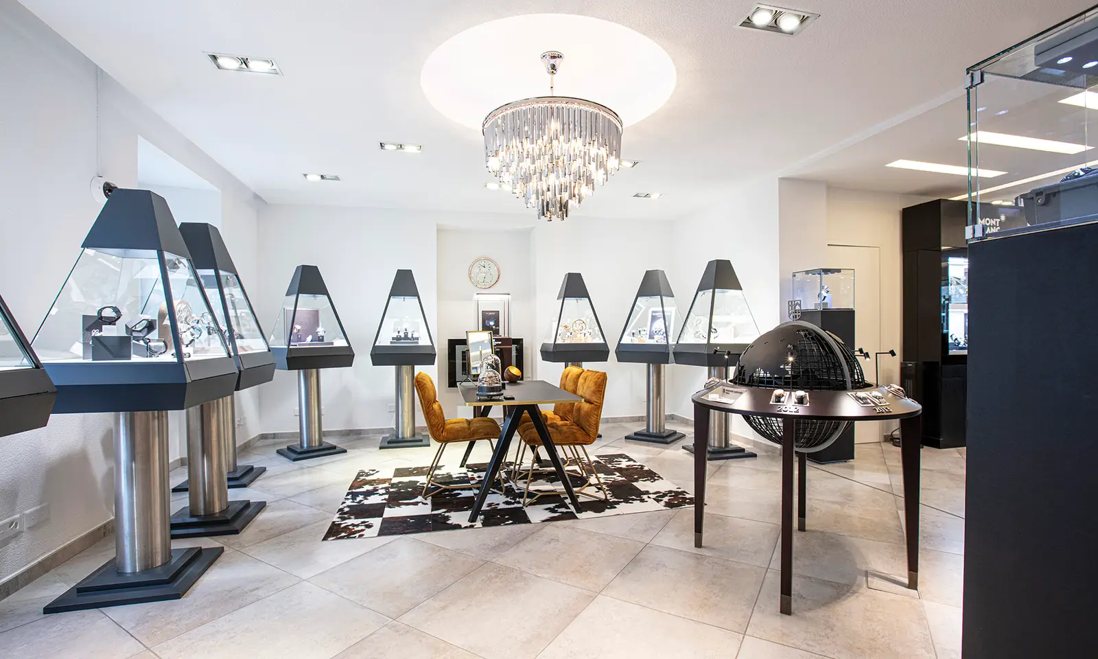 L’intérieur de la boutique du Sentier : vitrines en pyramide, lustre, chaises de velours
