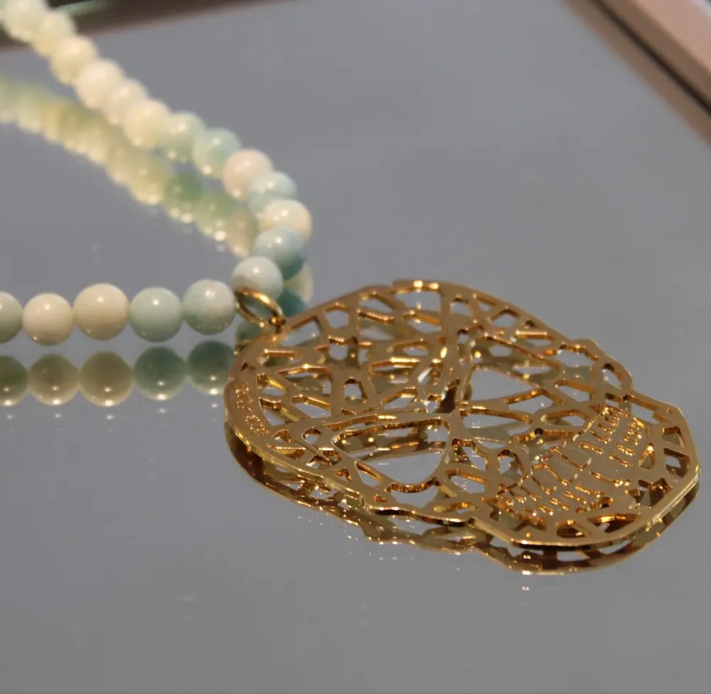 Rita&Zia — Sautoir avec pierre d’amazonite avec un pendentif doré symbole tête de mort